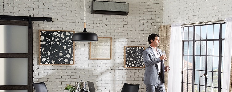 Man standing in apartment near wall-mounted mini split